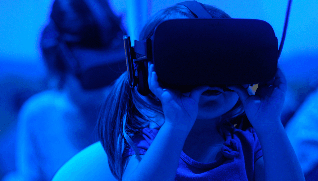 little girl wearing a virtual reality headset